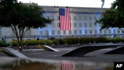 FILE - An American flag is unfurled at the Pentagon in Washington, Sept. 11, 2021, at sunrise on the morning of the 20th anniversary of the terrorist attacks. 