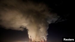 FILE - Smoke and steam billow from Belchatow Power Station, Europe's largest coal-fired power plant operated by PGE Group, at night near Belchatow, Poland, Dec. 5, 2018.