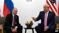 Presiden AS Donald Trump (kanan) dan Presiden Rusia Vladimir Putin berkelakar pada pertemuan di Osaka, Jepang, Jumat (28/6). 