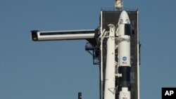 El brazo de acceso de la tripulación se coloca en posición para la nave espacial Dragon y el cohete SpaceX Falcon 9 en el Complejo de Lanzamientos 39A en preparación para la misión Demo-2, jueves 21 de mayo de 2020, en el Centro Espacial Kennedy, Florida.