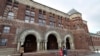 In this Dec. 5, 2019 photo, people walk near an entrance to a building at Harvard Law School, in Cambridge, Mass.