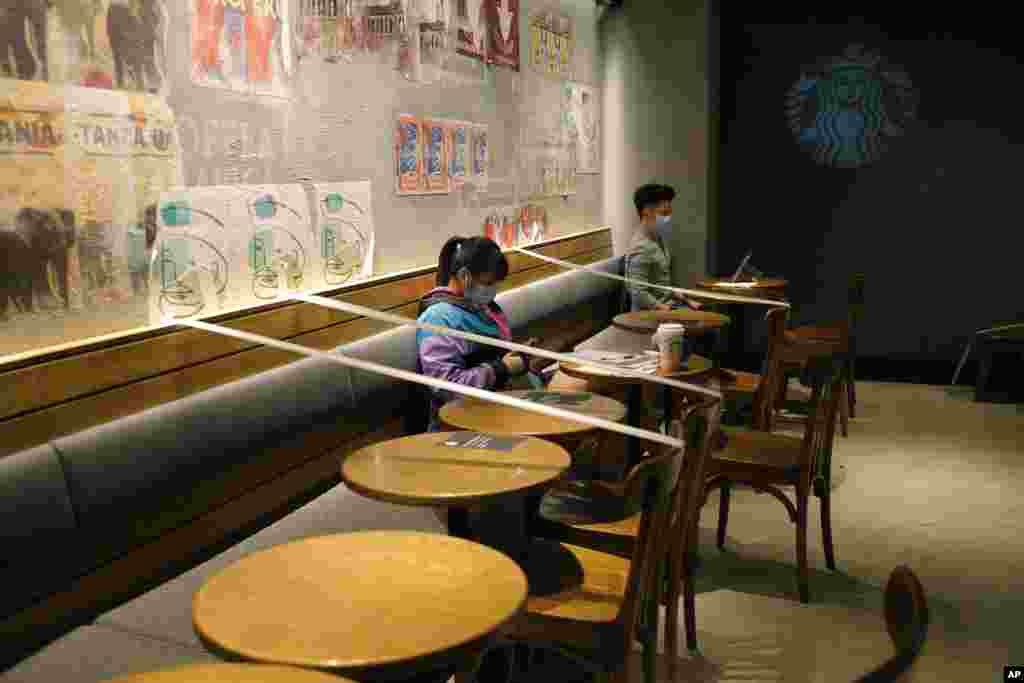 Tables and chairs are taped for the social distancing law enforcement to help curb the spread of the coronavirus at a Starbucks coffee shop in Hong Kong.