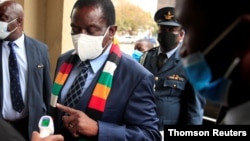 FILE PHOTO: Zimbabwe's President Mnangagwa has his temperature taken as he arrives at the parliament in Harare