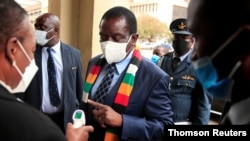 FILE PHOTO: Zimbabwe's President Mnangagwa has his temperature taken as he arrives at the parliament in Harare