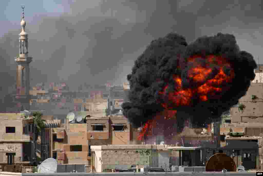 A ball of fire rises from a building following a reported airstrike by Syrian government forces on a rebel-held area in the southern city of Daraa.