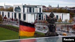 FILE - A German national flag flutters in front of the Chancellery in Berlin.