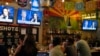 People sit behind a bar as they attend a watch party for the US Presidential debate between Vice President and Democratic presidential candidate Kamala Harris and former US President and Republican presidential candidate Donald Trump at American Eat Co. i