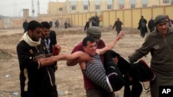 Protesters carry an injured man during clashes in Fallujah, 40 miles (65 kilometers) west of Baghdad, Iraq, January 25, 2013. 