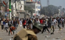 지난 24일 인도 뉴델리에서 시민권 개정법에 반대하는 시위대가 경찰과 개정법을 지지하는 시민들을 향해 돌을 던지고 있다.
