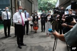 FILE - U.S. Health and Human Services Secretary Alex Azar, 2nd from left, answers to the media after visiting a mask factory in New Taipei City, Taiwan, Aug. 12, 2020.