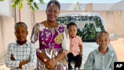 FILE - This family photo shows Pascazia Mazeze, executive director of the Tanzania Sickle Cell Warriors Organization, with her sons, from left, Ian, Rian and Gian outside their home in Tanzania on April 9, 2023.