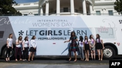 Đệ nhất phu nhân Michelle Obama chụp ảnh với nữ sinh trẻ ở phía trước Nhà Trắng trước khi một sự kiện kỷ niệm Ngày Quốc tế Phụ nữ tại Washington, DC, ngày 08/3/2016.