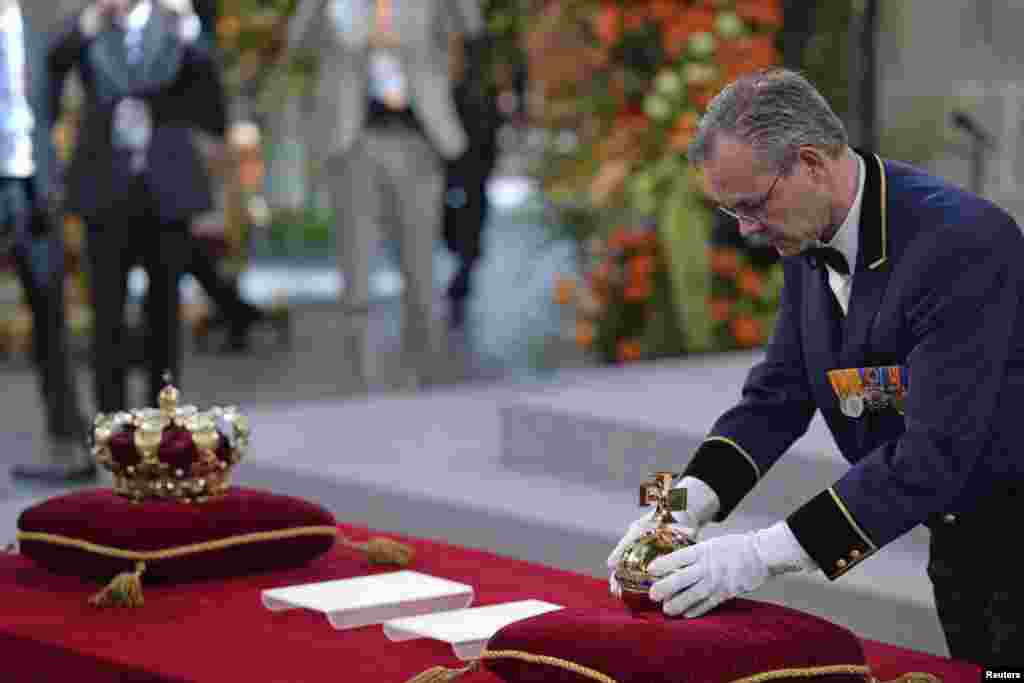 Peletakan lambang otoritas kerajaan Belanda, globus cruciger, sebelum upacara keagamaan di gereja Nieuwe Kerk di Amsterdam. Belanda merayakan Hari Ratu, yang juga menandai pengunduran diri Ratu Beatrix dan penobatan putra tertuanya Willem-Alexander.