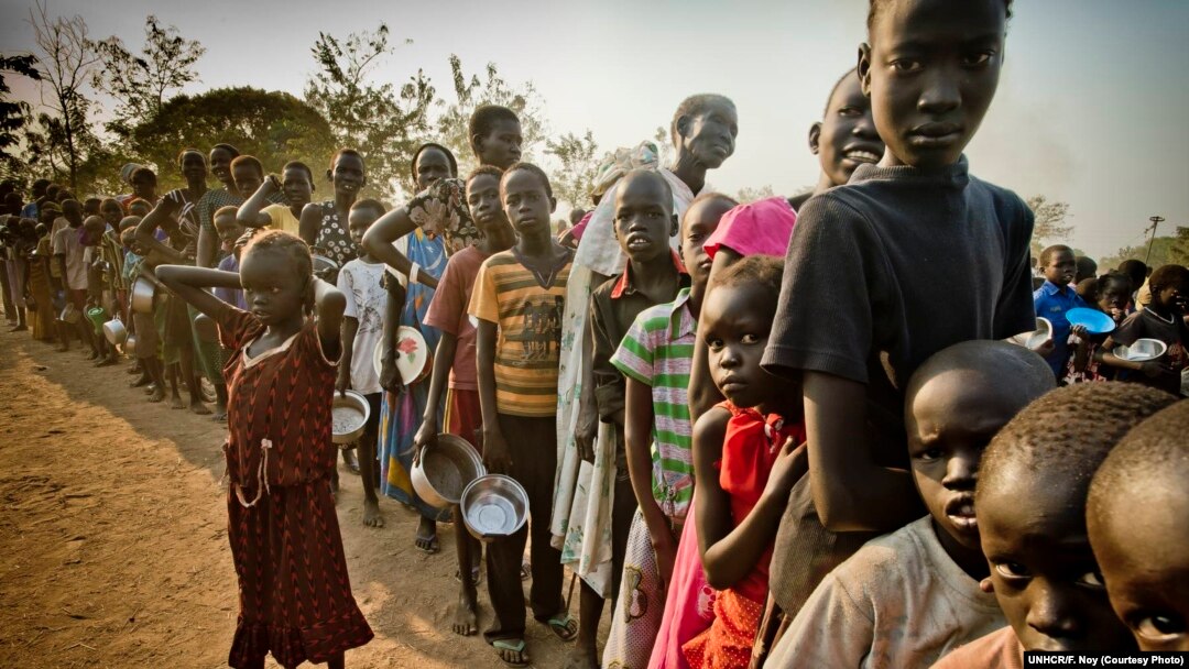 FILE - South Sudanese refugees wait in line to get food at Dzaipi transit camp in northern Uganda.