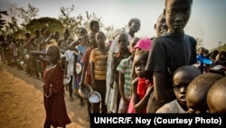 FILE - South Sudanese refugees wait in line to get food at Dzaipi transit camp in northern Uganda.