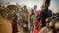FILE - South Sudanese refugees wait in line to get food at Dzaipi transit camp in northern Uganda.