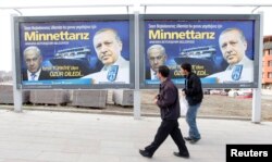FILE - Pedestrians look at billboards with the pictures of Turkey's Prime Minister Tayyip Erdogan, right, and his Israeli counterpart Benjamin Netanyahu, in Ankara.
