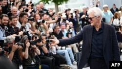 US actor Richard Gere filming with his mobile phone the photographers during a photocall for the film "Oh Canada" at the 77th edition of the Cannes Film Festival in Cannes, southern France, on May 18, 2024. (Photo by LOIC VENANCE / AFP)