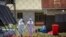 FILE - Doctors walk inside the Ebola isolation section of Mubende Regional Referral Hospital, in Mubende, Uganda, Sept. 29, 2022.