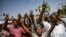 Sudanese protesters chant slogans and flash victory signs as they continue to demonstrate outside the army complex in Khartoum, April 17, 2019. They hardened their demand that the military men in power quickly step down.
