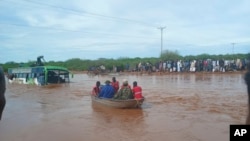 FILE—Passengers of a bus that was swept away by floodwaters are rescued by boat, near Garissa, northern Kenya, April 9, 2024. 