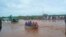 FILE—Passengers of a bus that was swept away by floodwaters are rescued by boat, near Garissa, northern Kenya, April 9, 2024. 