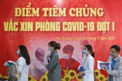 FILE - Health workers wait for their turn as Vietnam starts its official rollout of AstraZeneca's coronavirus vaccine for health workers, at Hai Duong Hospital for Tropical Diseases, Hai Duong province, Vietnam, March 8, 2021.
