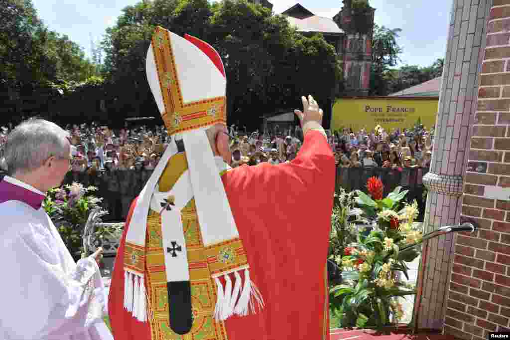 Pope Francis waves as he arrives to lead a Mass at St Mary's Cathedral in Yangon