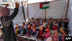 Anak-anak mengikuti kelas yang diajarkan oleh Israa Abu Mustafa (30) di tenda di tengah reruntuhan akibat perang antara Israel dan Hamas di Khan Yunis, Gaza Selatan, 4 September 2024. (Foto: AFP)