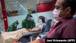 Para penyintas COVID-19 mendonorkan plasma konvalesen di kanto Palang Merah Indonesia di Surabaya, Jawa Timur, 18 September 2020. (Foto: Juni Kriswanto/AFP)