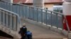 A woman rests on a footbridge, as Ghana enforces partial lockdown in the cities of Accra and Kumasi to slow the spread of the coronavirus disease (COVID-19) in Madina neighborhood of Accra, March 31, 2020. 