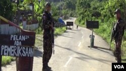 Personel Brimob melakukan penjagaan keamanan di Pos Sekat di desa Sedoa, Kecamatan Lore Utara, Kabupaten Poso, Sulawesi Tengah. (Foto: VOA/Yoanes).