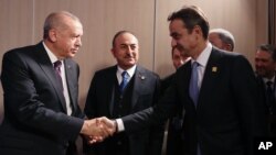 Presiden Turki Recep Tayyip Erdogan (kiri) bersalaman dengan Perdana Menteri Yunani Kyriakos Mitsotakis (kanan) dalam pertemuan bilateral di sela-sela KTT NATO di Watford, London. (Foto: Biro Setpres Turki via AP)