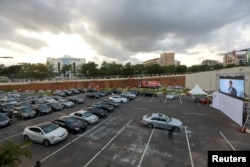 Movie audiences sit in their parked cars as they watch "Living in Bondage" at a drive-in cinema, following the relaxation of lockdown, amid the coronavirus disease (COVID-19) outbreak in Abuja, Nigeria, May 20, 2020.