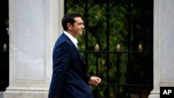 FILE - The leader of Greece's Syriza party Alexis Tsipras arrives at the Presidential Palace in Athens, Sept. 21, 2015.