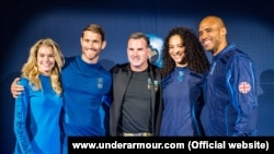 Under Armour Founder Kevin Plank stand with models wearing the UA-designed base layer and spacesuit.