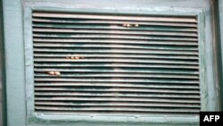 FILE - Prisoners' fingers are seen through a window after a riot by inmates in Lagos, Nigeria, Sept. 20, 2005. Correctional authorities said May 5, 2021, that an attack on Owerri prison in Imo state allowed 1,800 prisoners to escape. 