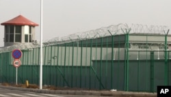 FILE - In this Dec. 3, 2018, file photo, a guard tower and barbed wire fence surround a detention facility in the Kunshan Industrial Park in Artux in western China's Xinjiang region.