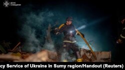 A firefighter works at a site of residential buildings heavily damaged by a Russian air strike in Sumy, Ukraine, Sept. 8, 2024.