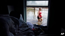 Emily Francois walks through floodwaters beside her flood-damaged home in the aftermath of Hurricane Ida, in Jean Lafitte, La., Sept. 1, 2021.