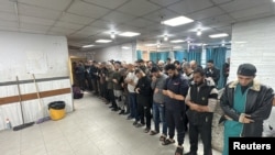 People pray next to the dead bodies of Palestinians at Kamal Adwan hospital, during the ongoing Israeli military operation, amid Israel-Hamas conflict, in Beit Lahiya, in the northern Gaza Strip, Dec. 17, 2024.