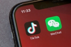 Icons for the smartphone apps TikTok and WeChat are seen on a smartphone screen in Beijing, Friday, Aug. 7, 2020. President Donald Trump has ordered a sweeping but unspecified ban on dealings with the Chinese owners of the consumer apps TikTok and…