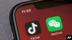 FILE - Icons for the smartphone apps TikTok and WeChat are seen on a smartphone screen in Beijing, Aug. 7, 2020.