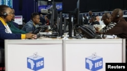 FILE - Election staff members work at the National Results Operation Centre of the Electoral Commission of South Africa (IEC), which serves as an operational hub where results of the national election are displayed, in Midrand, South Africa, May 30, 2024. 