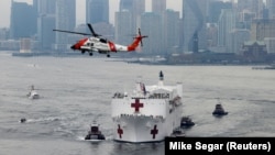 A U.S. Coast Guard helicopter flies above USNS Comfort as it enters New York Harbor during the outbreak of the coronavirus disease (COVID-19) in New York City, U.S., March 30, 2020. (REUTERS/Mike Segar)