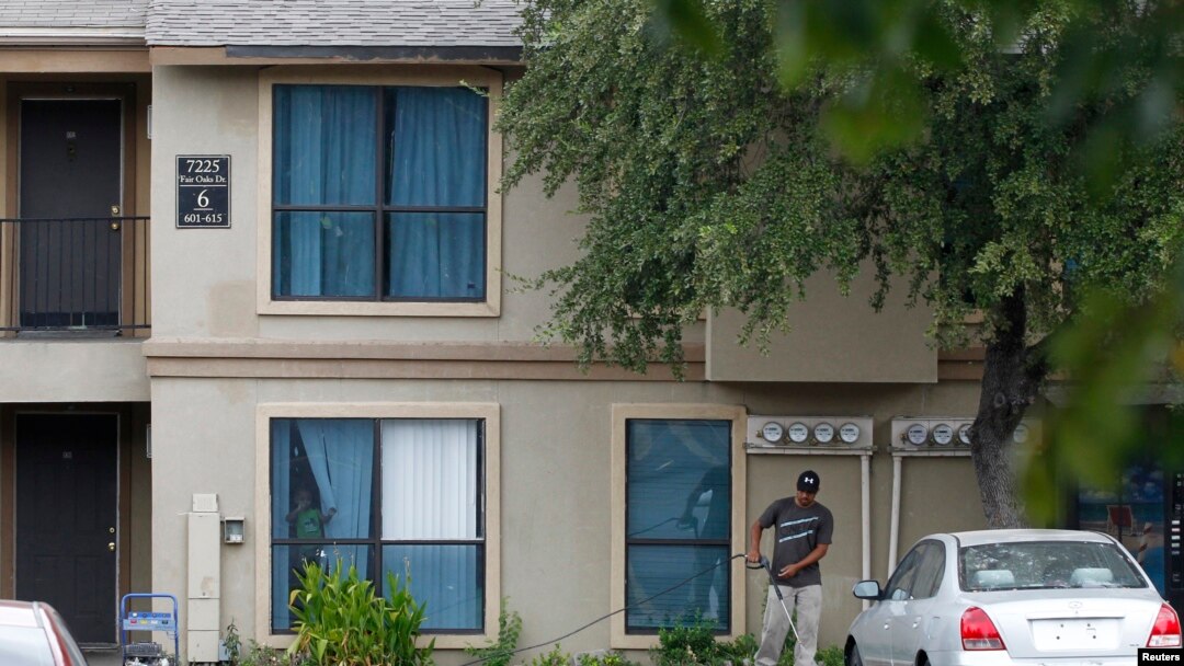 A worker powerwashes sidewalk in front The Ivy Apartments, where a man diagnosed with the Ebola virus was staying, Dallas, Texas, Oct. 2, 2014.