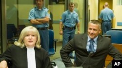 那瑟尔·欧利克（右）2008年7月3日在荷兰海牙法庭受审时与律师在一起。