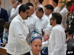 El presidente de Venezuela, Nicolás Maduro saluda al comandante de la guerrilla de las FARC de Colombia, Iván Márquez, durante la firma del cese al fuego entre el gobierno colombiano y la guerrilla de las FARC en La Habana el 23 de junio de 2016.