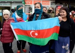 People hold the national flag after Azerbaijan's President Ilham Aliyev said the country's forces had taken Shusha, which Armenians call Shushi, during fighting over the breakaway region of Nagorno-Karabakh, in Azerbaijan, Nov. 8, 2020.