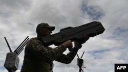 A Ukrainian serviceman tests an anti-drone gun during a presentation of radio-electronic warfare and radio-electronic intelligence systems of the Ukrainian company Kvertus in Lviv region on May 28, 2024.